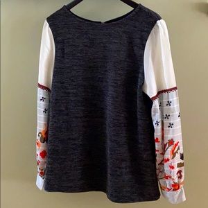 Grey top with blouson sleeves.